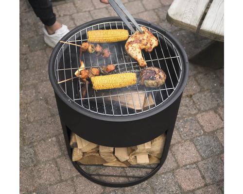 "Een houtskoolgrill met gegrilde producten zoals kip, maiskolven en vleesspiesen wordt omgedraaid met een grilltang