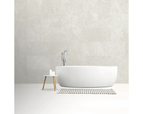 Vrijstaand bad met kraan, bijzettafel met kaarsen en gestreept vloerkleed in de badkamer.