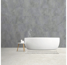 Badkamer met vrijstaand bad, kraan en wandbekleding in betonlook