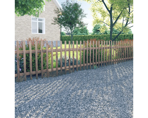 Tuinbeeld met houten hek, grindpad en huis op de achtergrond