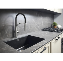 Keukenscène met spoelbak, kraan, kookplaat en werkblad in een modern design.