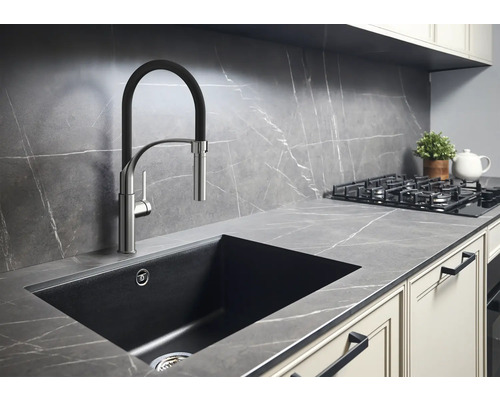 Keukenscène met spoelbak, kraan, kookplaat en werkblad in een modern design.