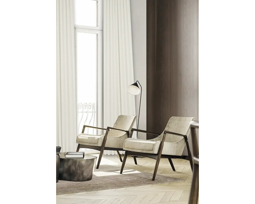 Woonkamer met twee fauteuils, een staande lamp en gordijnen voor het raam.