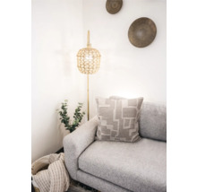 Lichte interieurscène met bank, kussen met geometrisch patroon en staande lamp