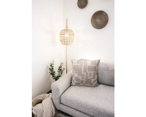 Lichte interieurscène met bank, kussen met geometrisch patroon en staande lamp