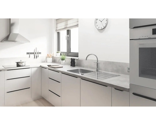 Lichte keuken met spoelbak, kraan, afzuigkap en keukengerei