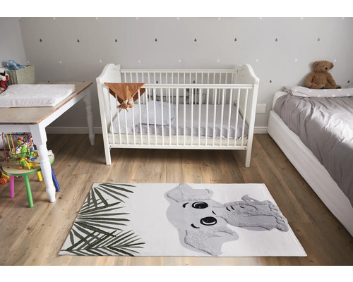 Kinderkamer met babybed, commode, bed en vloerkleed met olifantenmotief.
