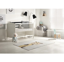 Lichte kinderkamer met ledikant, staande lamp, kinderstoel en vloerkleed met diermotief