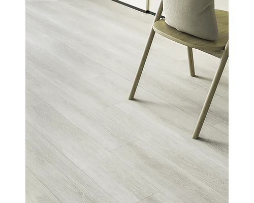 Lichte vinylvloer met houtlook en een stoel met kussen.