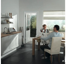 Lichte keuken met vliegengordijndeur, man leest krant aan tafel