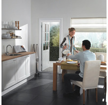 Lichte keuken met eettafel, insectenwerend gordijn bij de deur.