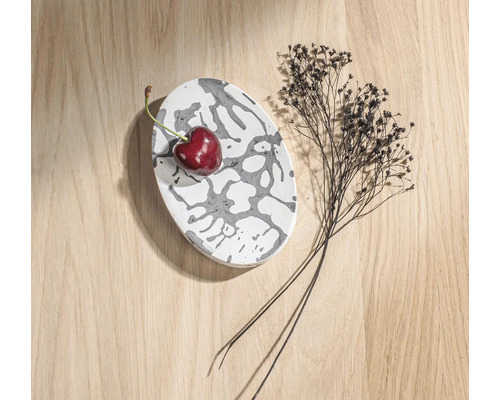 Decoratieve ovale schaal met patroon, kers en droogbloemen op houten tafel