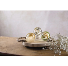 Drie decoratieve bollen met plantenmotieven op een houten dienblad