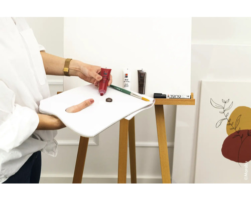 Scene met acrylverf, penseel, palet en doek op een ezel.