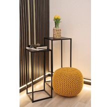 Twee bijzettafels met zwart metalen frame, een gele poef en een vaas met gele tulpen