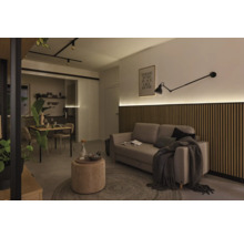 Woonkamer met bank, houten wandpanelen, lamp en eettafel