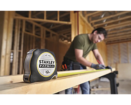 Stanley Fatmax rolmaat naast vakman die hout bewerkt