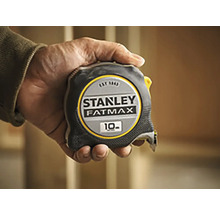 Stanley Fatmax rolmaat met een lengte van 10 meter in een hand gehouden.
