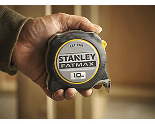Stanley Fatmax rolmaat met een lengte van 10 meter in een hand gehouden.