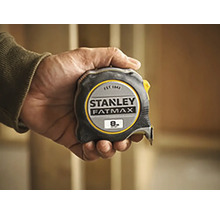 Hand houdt een Stanley Fatmax rolmaat vast met een lengte van acht meter