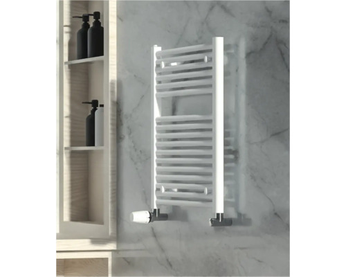 Badkamerscène met een witte handdoekradiator aan een marmeren muur