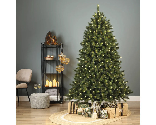 Kerstboom met verlichting en cadeaus in een feestelijk ingerichte woonkamer.