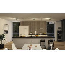 Moderne keuken met kookeiland, eettafel en flexibele railverlichting.