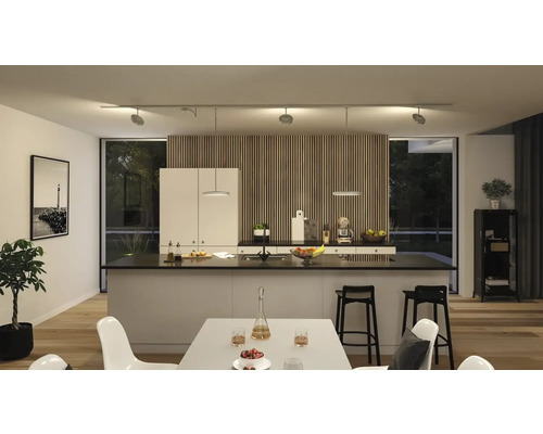 Moderne keuken met kookeiland, eettafel en flexibele railverlichting.