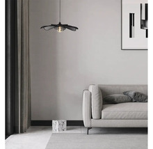 Interieurfoto van een woonkamer met een decoratieve bloemvormige hanglamp boven een bank.