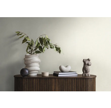 Decoratieve scène met een bloemenvaas, sculpturen en boeken op een donkerhouten kast.