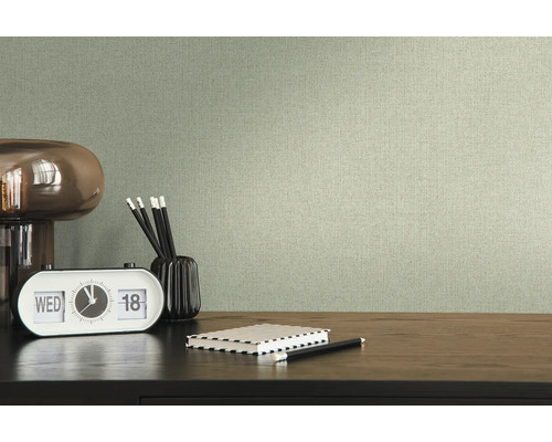 Textielbehang in woonkamer met bureau, lamp, klok, pennen en notitieboek