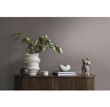 Decoratief arrangement op een houten kast met vaas, boeken en sculptuur