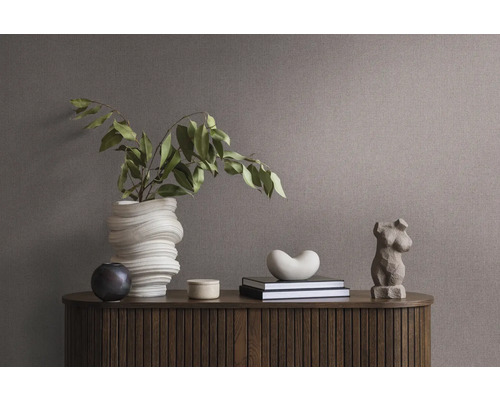 Decoratief arrangement op een houten kast met vaas, boeken en sculptuur