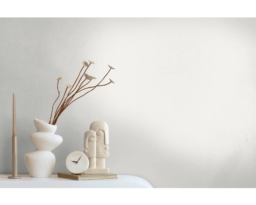 Decoratieve opstelling met vaas, planten, kaars, klok en sculptuur op een tafel