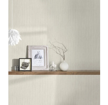 Scene met een lichtgekleurd behang met verticaal patroon, een houten plank met decoratieve objecten zoals fotolijsten en een vaas