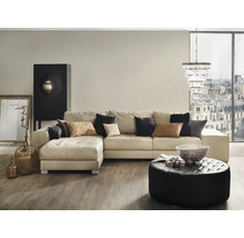 Woonkamer met hoekbank, poef, salontafel en decoraties.