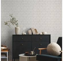 Woonkamer met een wand in baksteenlook, een dressoir en een fauteuil