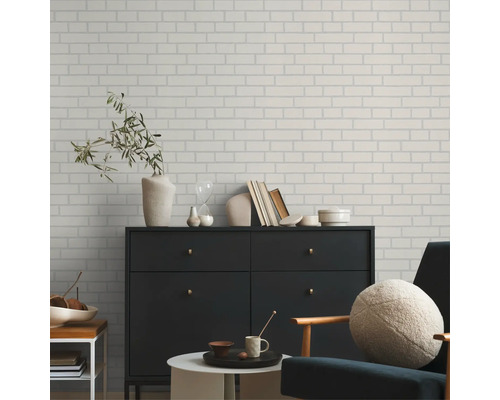 Woonkamer met een wand in baksteenlook, een dressoir en een fauteuil