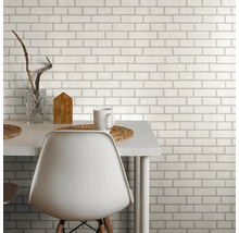 Behang met baksteenmotief achter een eettafel met stoel