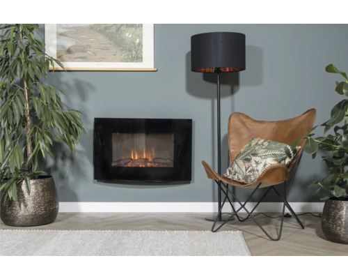 Woonkamer met elektrische open haard, vloerlamp, fauteuil en kamerplanten voor een gezellige sfeer