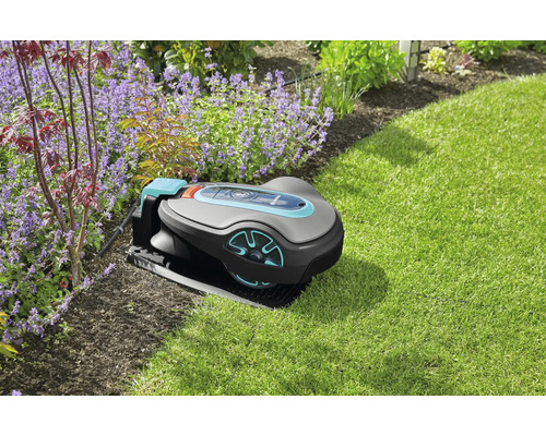 Gardena robotmaaier op gazon naast bloembed