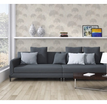 Woonkamer met grijze bank, boekenplank en decoratief behang met plantmotieven.