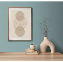 Decoratief ingelijst wandkunstwerk met abstract geometrisch ontwerp op een tafel met vaas, kop en boeken