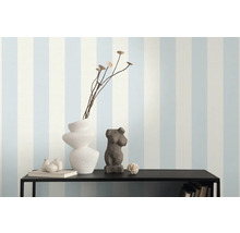 Decoratieve schikking op een plank tegen een gestreept behang