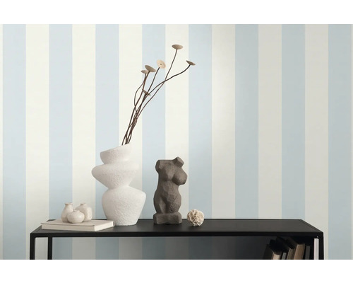 Decoratieve schikking op een plank tegen een gestreept behang