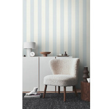 Woonkamer met gestreept behang en een fauteuil met houten poten