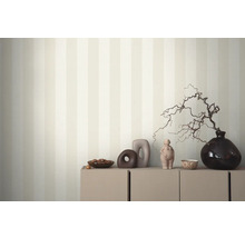 Decoratief interieur met gestreept behang, kast en diverse decoratieve objecten.