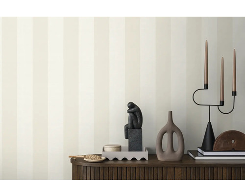 Decoratief interieur met behang, sculptuur en kandelaar op een dressoir.