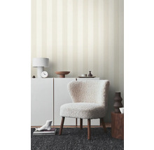 Woonkamer met gestreept behang, fauteuil en witte meubels voor een heldere sfeer