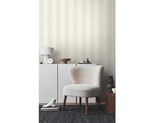 Woonkamer met gestreept behang, fauteuil en witte meubels voor een heldere sfeer